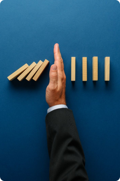 Mains limitant la chute de dominos symbolisant la gestion des risques